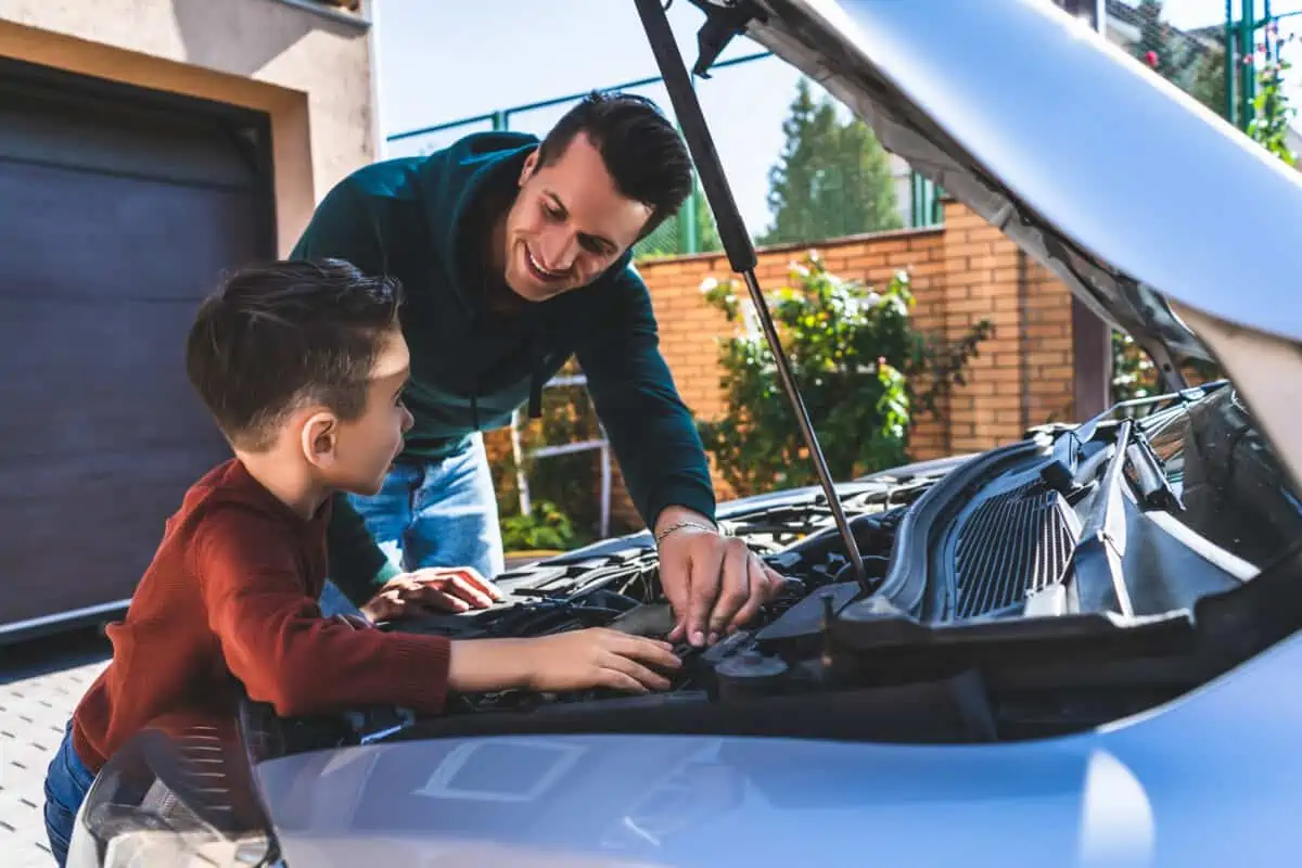 A man and boy looking inside the bonnet of a car