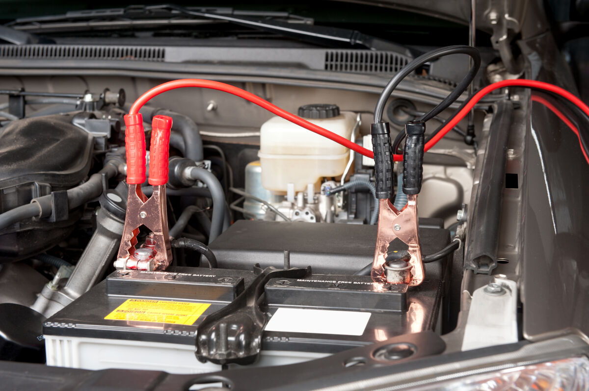 Battery maintainer cables transferring power to a battery still in the engine compartment