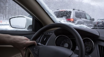 Photo through inside of a car windscreen, driving on a cold, snowy day