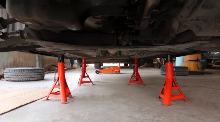 A pair of red jack stands supporting a raised car
