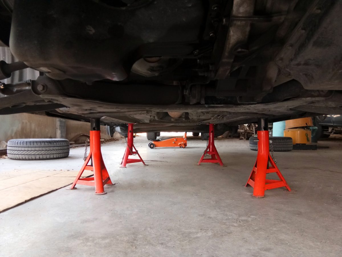 A pair of red jack stands supporting a raised car