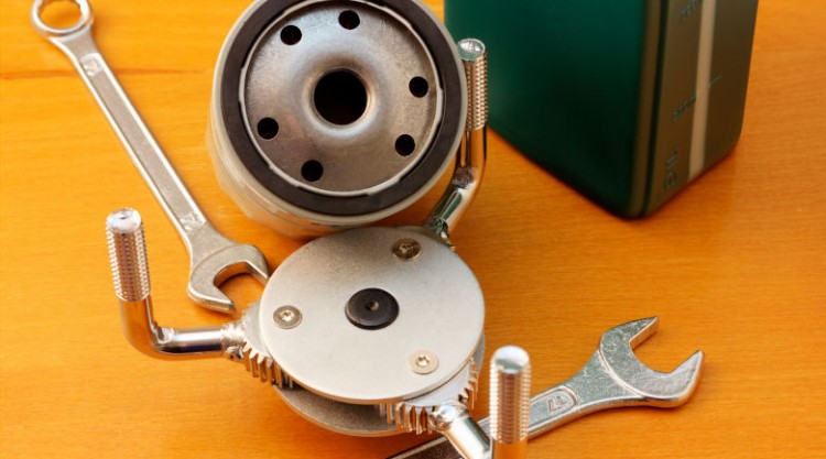 Oil filter wrench, filter and spanner on a yellow background