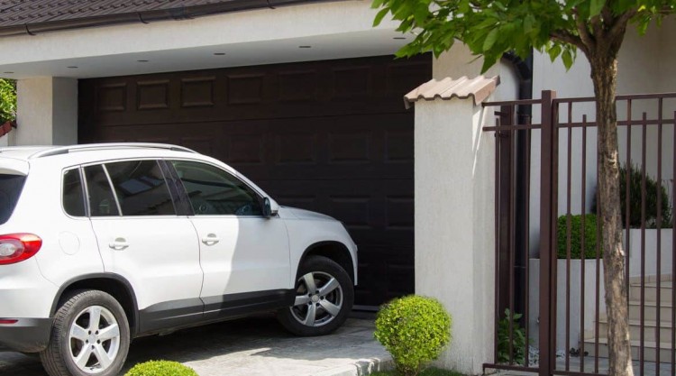 A white SUV approaching the garage parking door