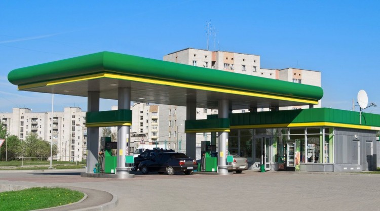 Gas station with cars lining up and getting their engines filled up and ready to go