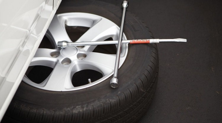 Spare tire being installed on a car to drive on