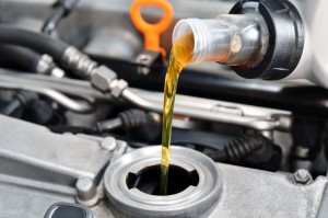 Car owner filling up his vehicle's engine with motor oil