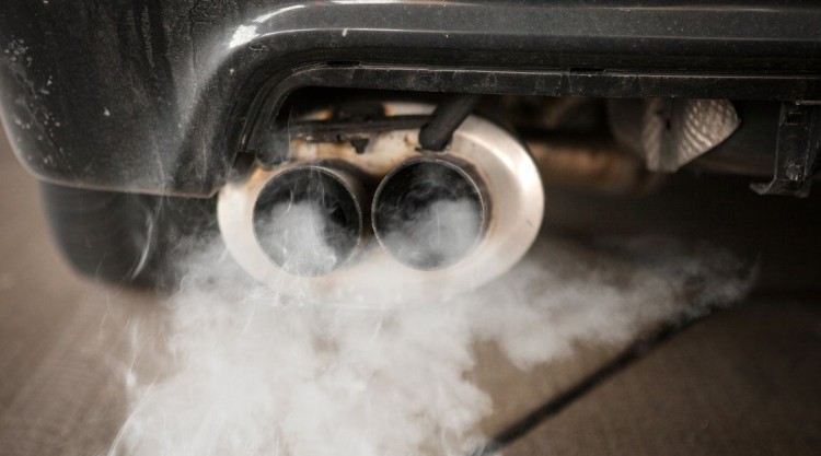 Black car with white smoke coming out from the rear exhaust