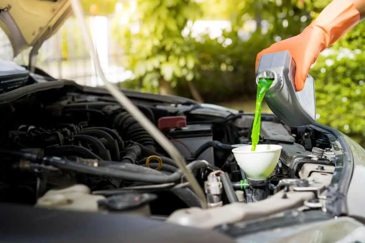 Green antifreeze being poured into a car engine