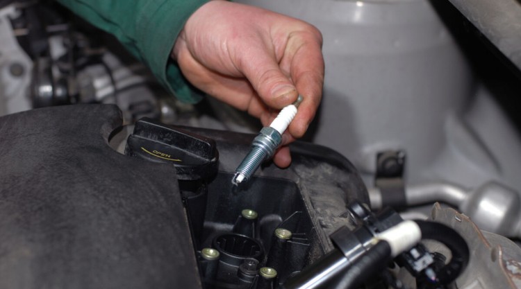 Close up of mans hands changing spark plugs