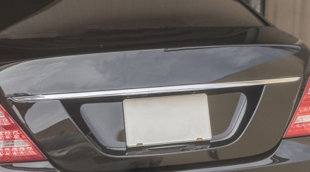 Close up of blank license plate frame on a black saloon type car