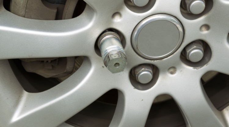 Close up of a locking lug nut on a car wheel