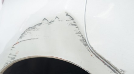 A scuff with paint transfer on the side of a white car