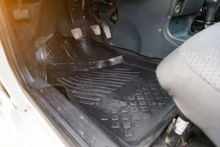 A poorly fitted car floor mat buckling underneath the pedals