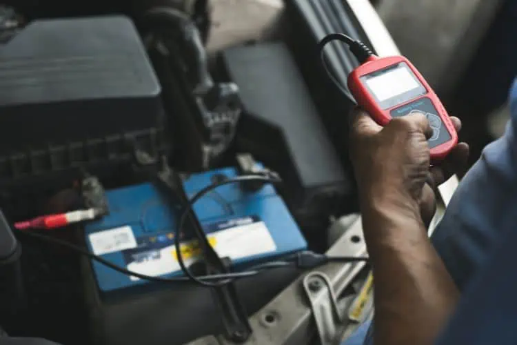 Man using a car battery load tester