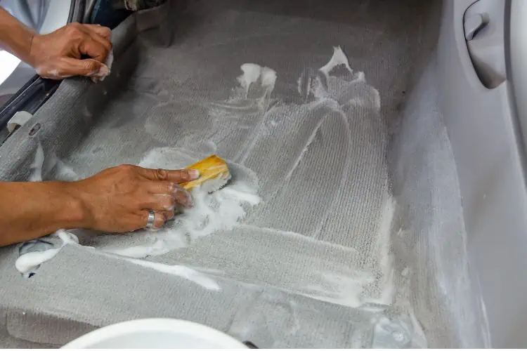 Man scrubbing gar carpet with soapy carpet cleaner