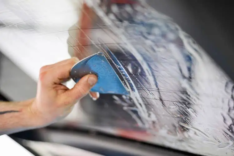 Professional applying tint film to car window